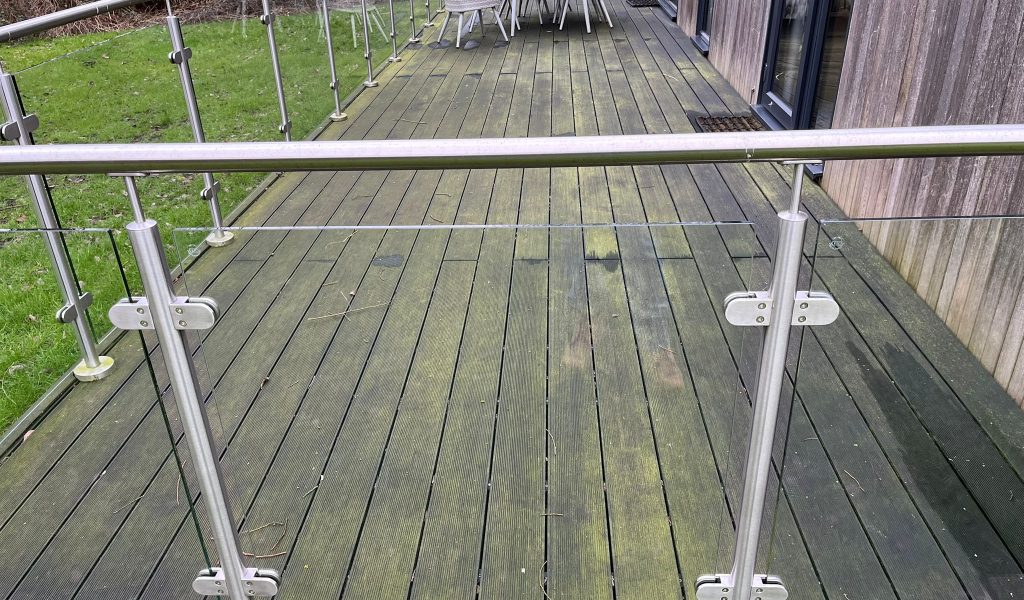 Wooden decking covered in algae and moss before professional pressure washing, Somerset