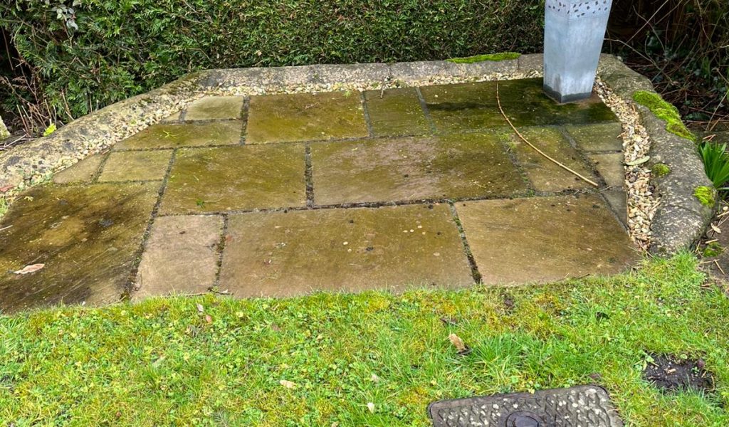Patio slabs with years of grime and moss before pressure washing – Frome, Somerset